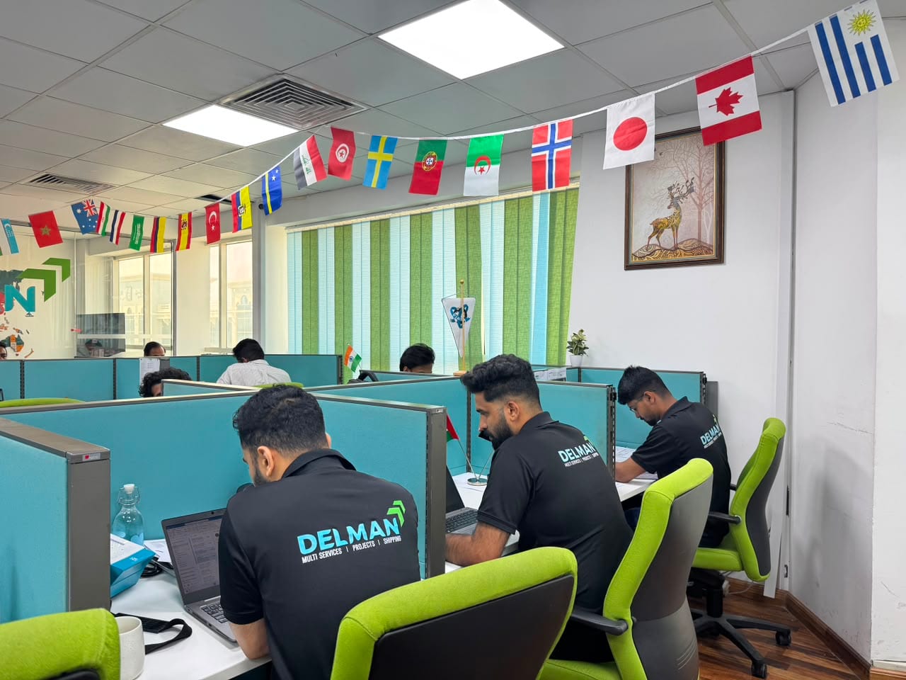 Delman Shipping team at work in the Dubai office, desks decorated with international flags
